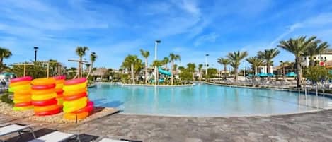 A pool area with lounge chairs and a water slide.