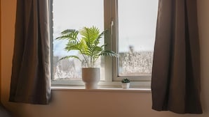 A window with a potted plant and a small pot on the windowsill. - 3bed House - Close to Worksop Mansfield (Mansfield)
