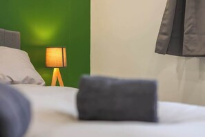 A neatly made bed with a pillow, a bedside lamp, and a dark-colored blanket. - 3bed House - Close to Worksop Mansfield (Mansfield)