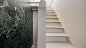 A modern staircase with a marble wall on one side and a plain wall on the other. - w Dreamy 1BR w Private Terrace Skyline View (Milan)