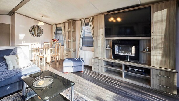 A modern living room with a sofa, coffee table, TV, and fireplace. - Host Stay 10th Avenue (Morpeth)