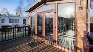 A wooden deck with a glass door entrance, a small porch, and a visible backyard. - Host Stay 10th Avenue (Morpeth)