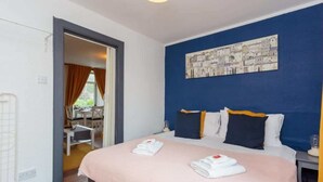 A hotel room with a bed, a desk, and a chair. - 1 Bedroom Scottish Cottage-on Street Parking (Selkirk)