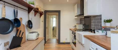 A compact kitchen with wooden countertops, a built-in oven, and a washing machine.