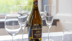 A bottle of Nozeco wine and three empty wine glasses on a table. - 1 Bedroom Scottish Cottage-on Street Parking (Selkirk)