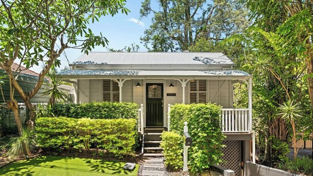 A white two-story house with a front porch, a mailbox, and a well-maintained lawn. - 1920s Cottage Near Paddington and CBD (Bardon)