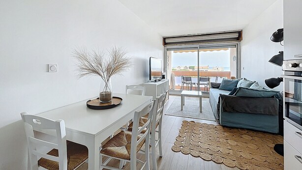 Un espacio de estar moderno con comedor, sofá y vistas al exterior.