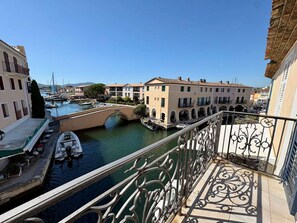 A canal with boats, a bridge, and buildings with balconies. - Charming Duplex in Port Grimaud with Balconies and Parking (Port Grimaud)