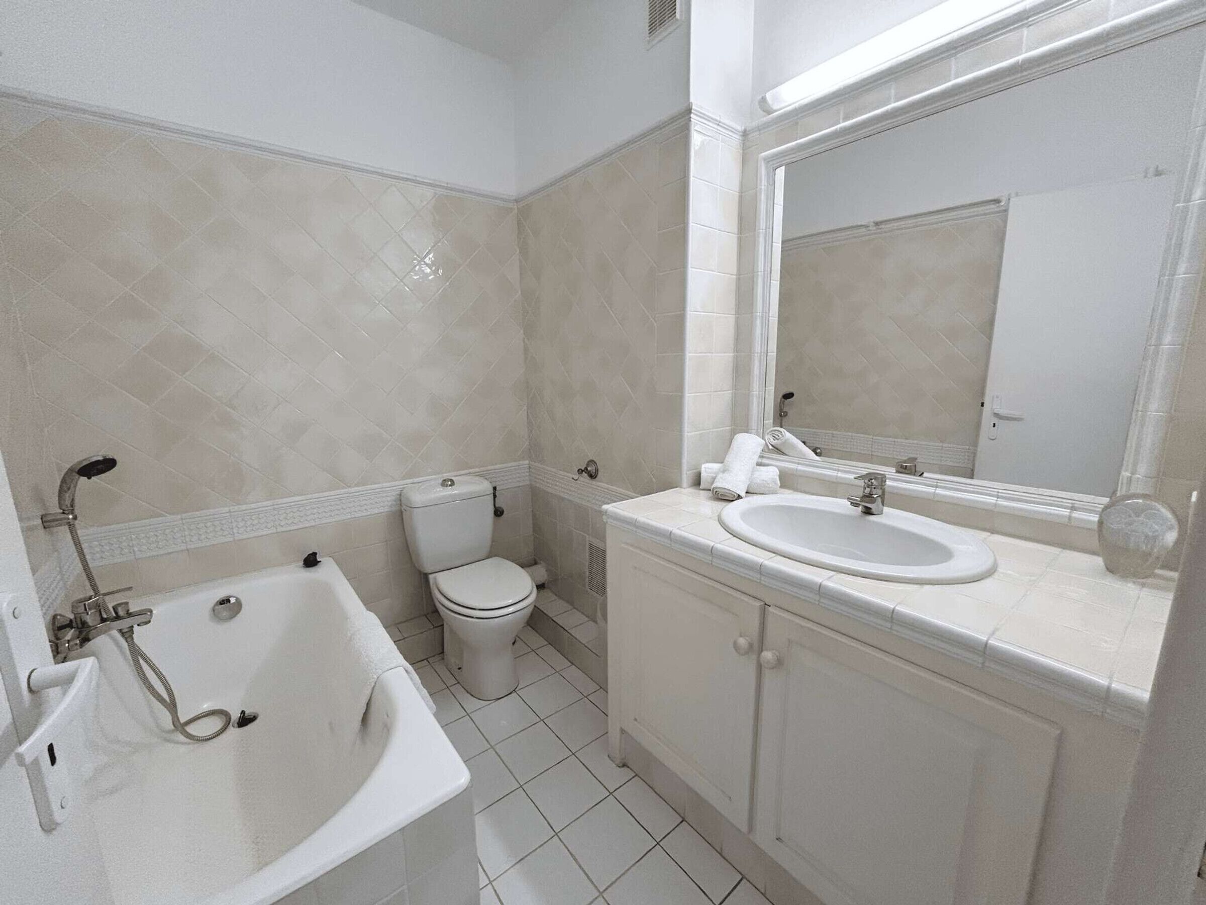 A bathroom with a bathtub, toilet, and sink.