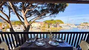 Mesa posta para dois, com vista para uma marina e edifícios do outro lado da água.