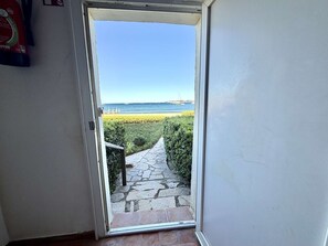A doorway leading to a stone pathway and a view of the sea. - 4-room apartment with balcony, sea view, wifi and parking (Port Grimaud)