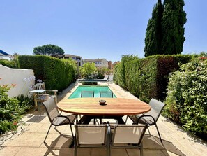 A patio with a pool, surrounded by hedges and a tall tree. - Port Grimaud House: 4 Bedrooms, Pool, Private Mooring (Port Grimaud)