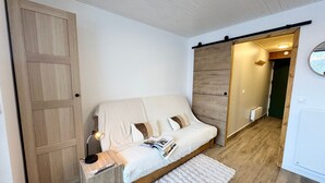 A bedroom with a bed, bedside table, lamp, and a large wardrobe. - Vars - Cozy Apartment for 4 People (Vars)