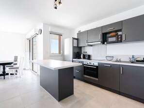 Fridge, microwave, oven, stovetop - Spacious 2-Bedroom Apartment with WiFi, AC, Balcony, and Parking near Narbonne Beach (Narbonne-Narbonne Plage-Narbonne Plage)