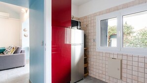 A compact kitchen with a refrigerator, a window, and a tiled backsplash. - Air-conditioned pavilion for 6 pers. with parking & bikes in Gruissan (Gruissan)
