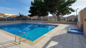 A rectangular swimming pool with a metal ladder, surrounded by a tiled deck. - Air-conditioned pavilion for 6 pers. with parking & bikes in Gruissan (Gruissan)