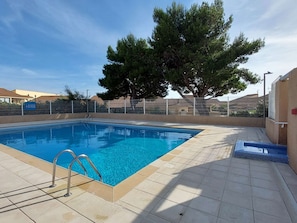 A rectangular swimming pool with a metal ladder, surrounded by a tiled deck. - Air-conditioned pavilion for 6 pers. with parking & bikes in Gruissan (Gruissan)