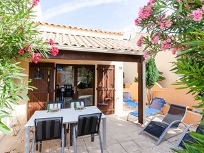 A patio area with a table and chairs, a covered seating area, and a view of the street. - Studio Pavilion in Narbonne-Plage with Pool (Narbonne)