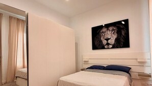 A bedroom with a bed, a large mirror, a painting of a lion, and a wooden floor. - Detached house in the center of Santa Cruz de Tenerife (Santa Cruz)