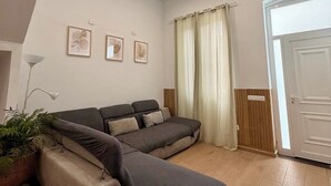 A modern living room with a sectional sofa, a floor lamp, and a potted plant. - Detached house in the center of Santa Cruz de Tenerife (Santa Cruz)