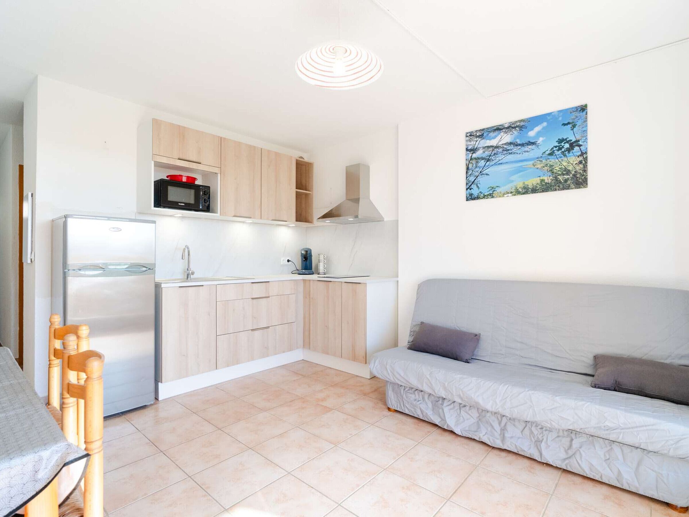 Un espacio habitable pequeño con kitchenette, un sofá y un comedor.