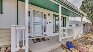 A house with a green porch, white exterior, and a blue potted plant on the steps. - 4 Mi to Riverwalk & CSU Pueblo! Home w/ Sunroom (Pueblo)