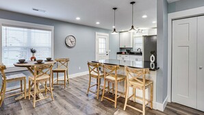 A modern kitchen with wooden chairs, a dining table, and a clock on the wall. - Peaceful Retreat Near Lake Barkley! (Cadiz)