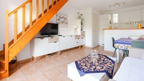 Un appartamento moderno con una scala in legno, un'area pranzo e una cucina.