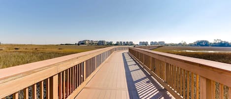 Un muelle de madera que lleva a edificios a lo lejos.