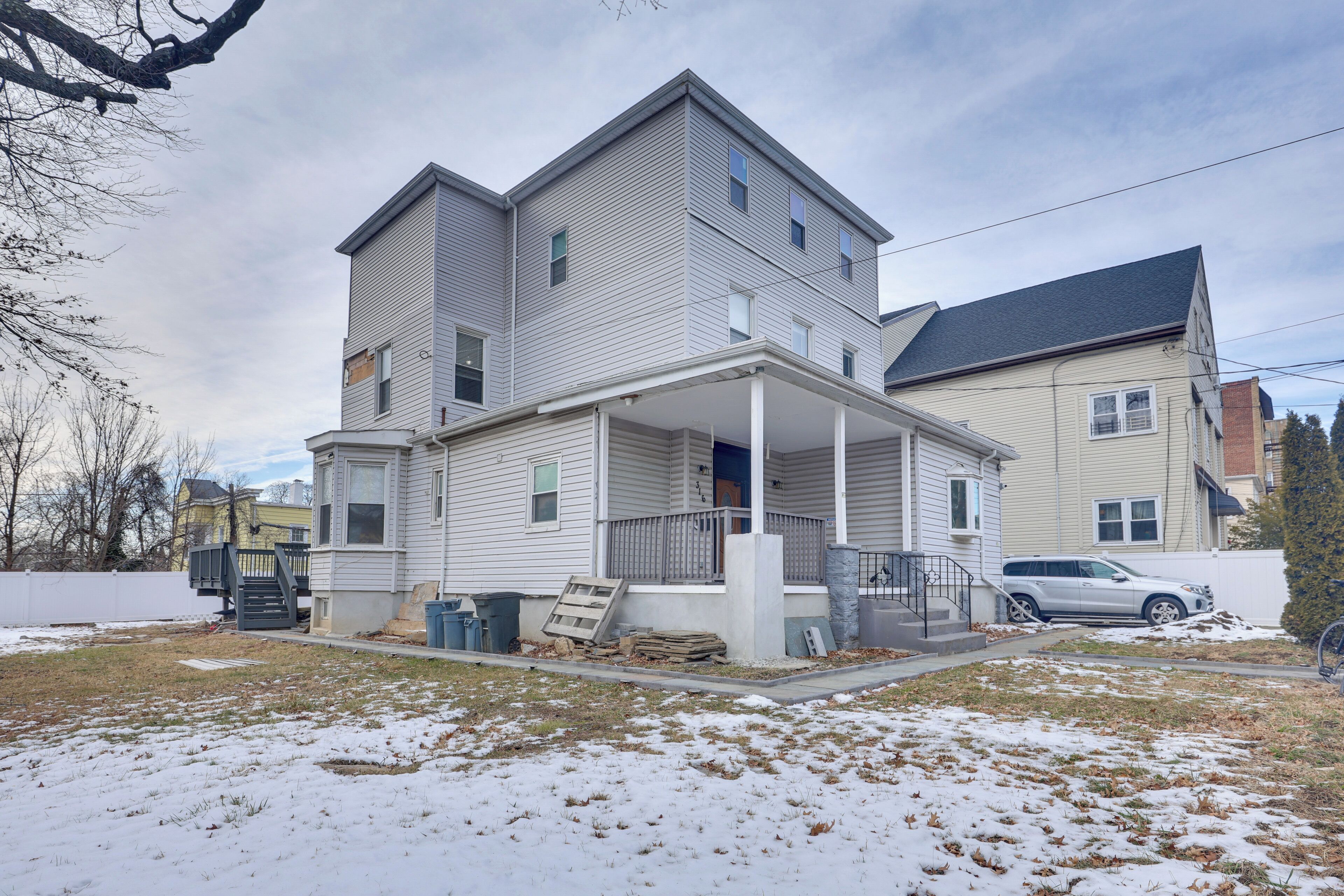 A two-story house with a covered porch and a garage.