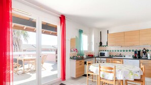 Una cocina luminosa con armarios de madera, un microondas y una cafetera.
