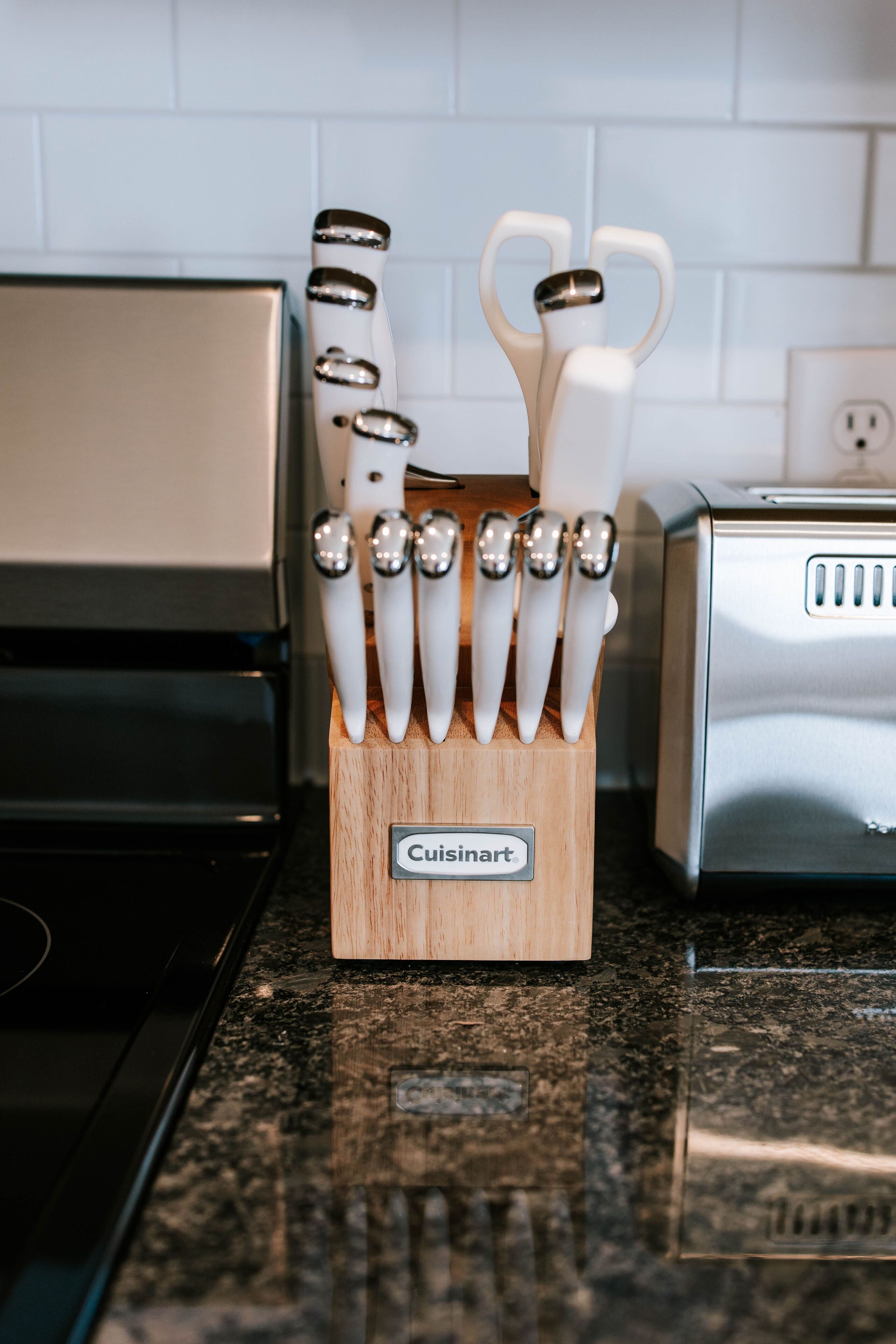 A kitchen counter with a knife block labeled "Cuisinart" and a toaster.