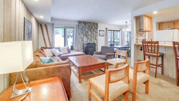 A spacious living room with a fireplace, wooden furniture, and a stone accent wall. - 1 Mi to Village & Eagle Lodge! Extended Stay Unit (Mammoth Lakes)