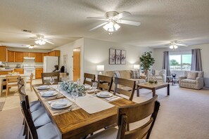 A spacious living area with a dining table set for six, wooden furniture, ceiling fans, and a view of the outdoors. - Yard, Patio & Grill! Florence Home Near Monastery (Florence)