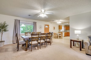 A dining area with a wooden table and chairs, a ceiling fan, and a view into the kitchen. - Yard, Patio & Grill! Florence Home Near Monastery (Florence)