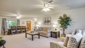 A spacious living room with a ceiling fan, a dining area with wooden furniture, and a large plant. - Yard, Patio & Grill! Florence Home Near Monastery (Florence)
