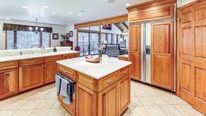 Una cocina amplia con armarios de madera, una isla grande y vistas al exterior.