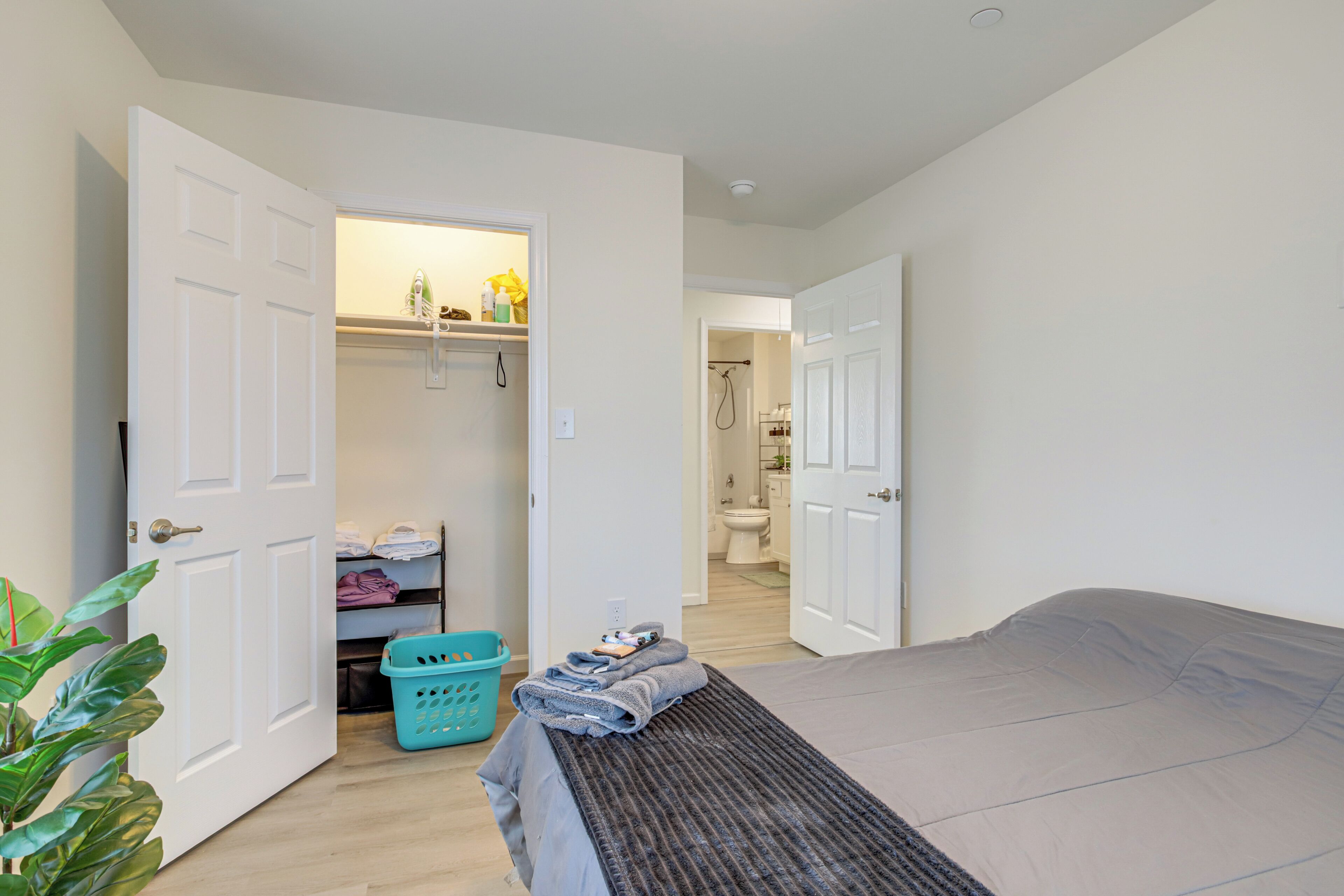 A bedroom with a bed, a closet, and a bathroom visible through an open door.