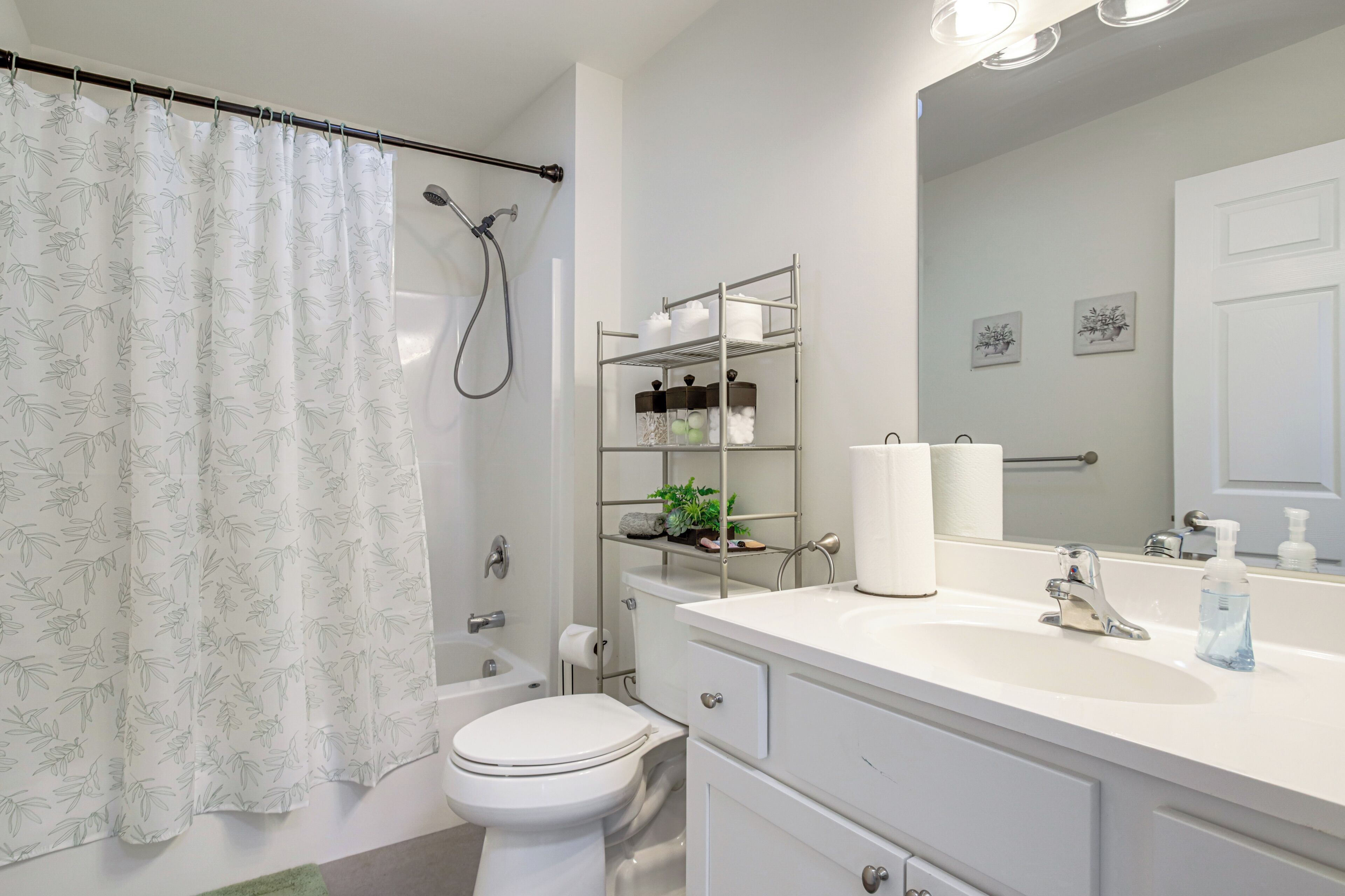 A modern bathroom with a shower, toilet, and a vanity with a mirror.