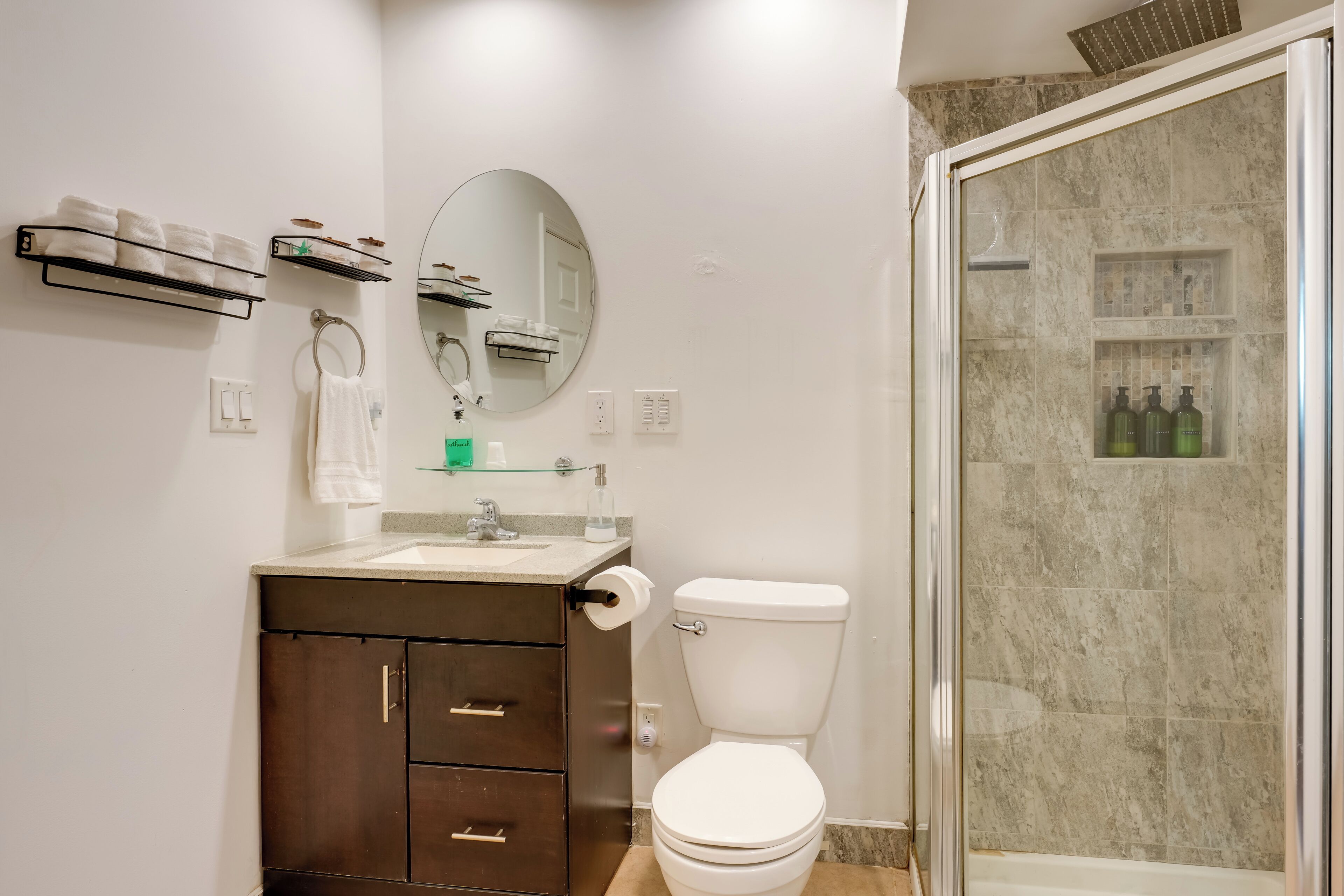 Un baño moderno con inodoro, lavabo y ducha.
