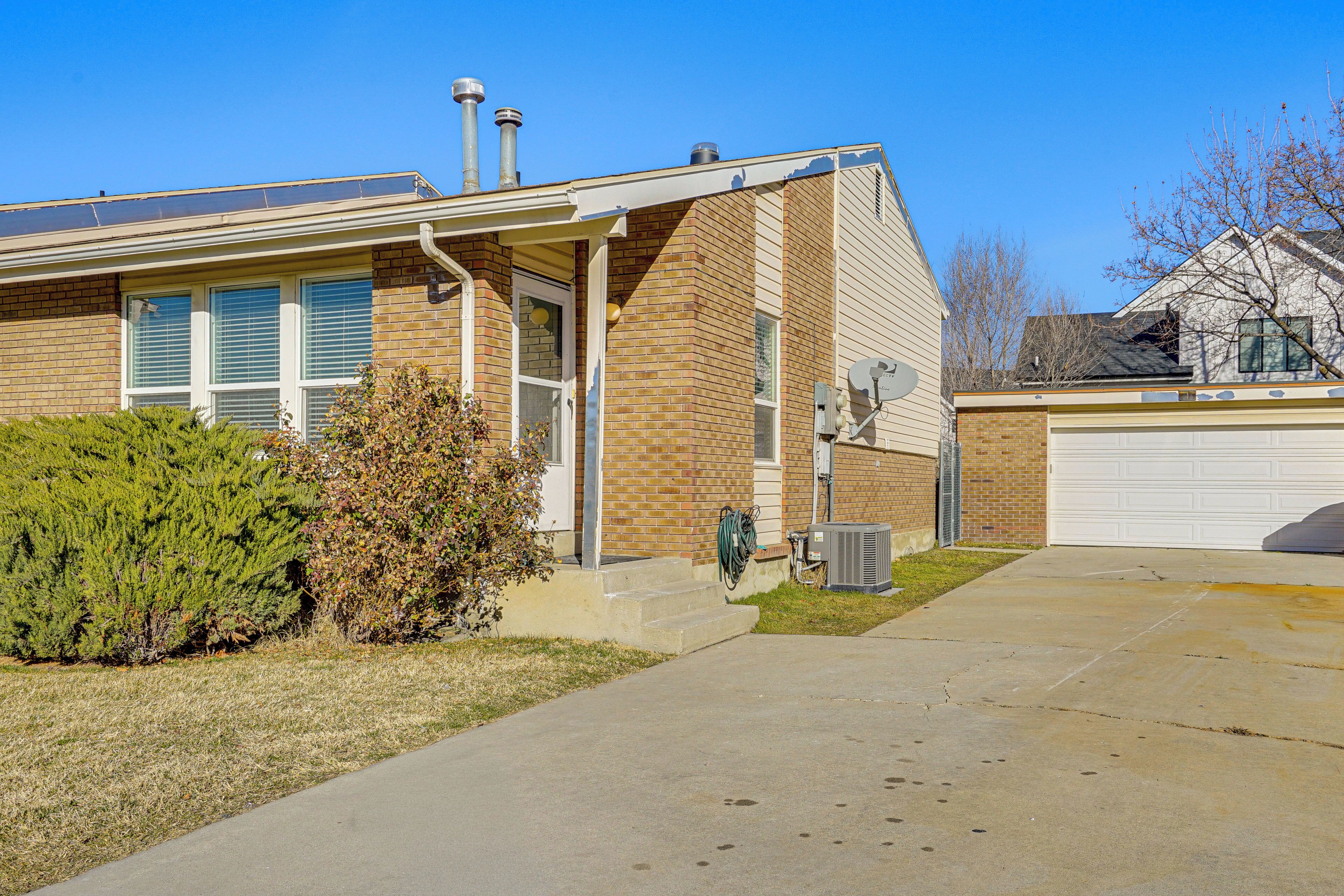 A two-story house with a brick exterior, a front porch, and a garage.