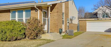 A two-story house with a brick exterior, a front porch, and a garage.