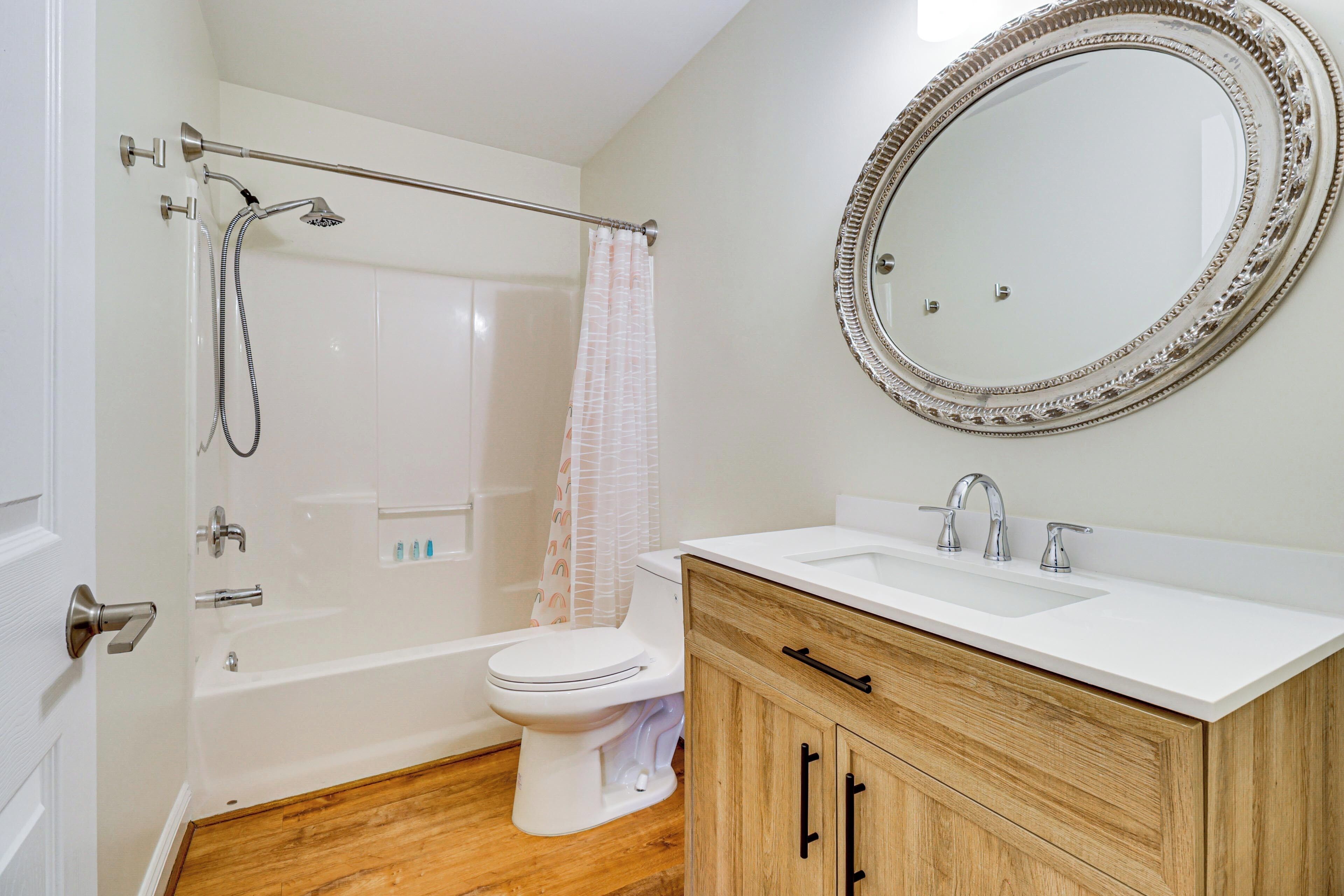 A bathroom with a bathtub, toilet, and sink.