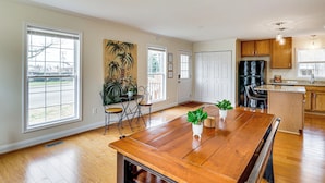 A spacious kitchen with wooden cabinets, a dining area with a large table, and a view through the windows. - Walk to Dtwn & Campus! Spacious Hampton Home (Hampton)