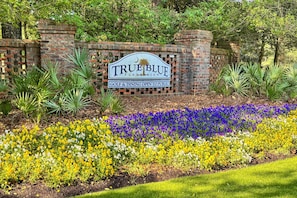 Schild für True Blue Plantation mit Golf- und Gastronomiebereich, öffentlich zugänglich.