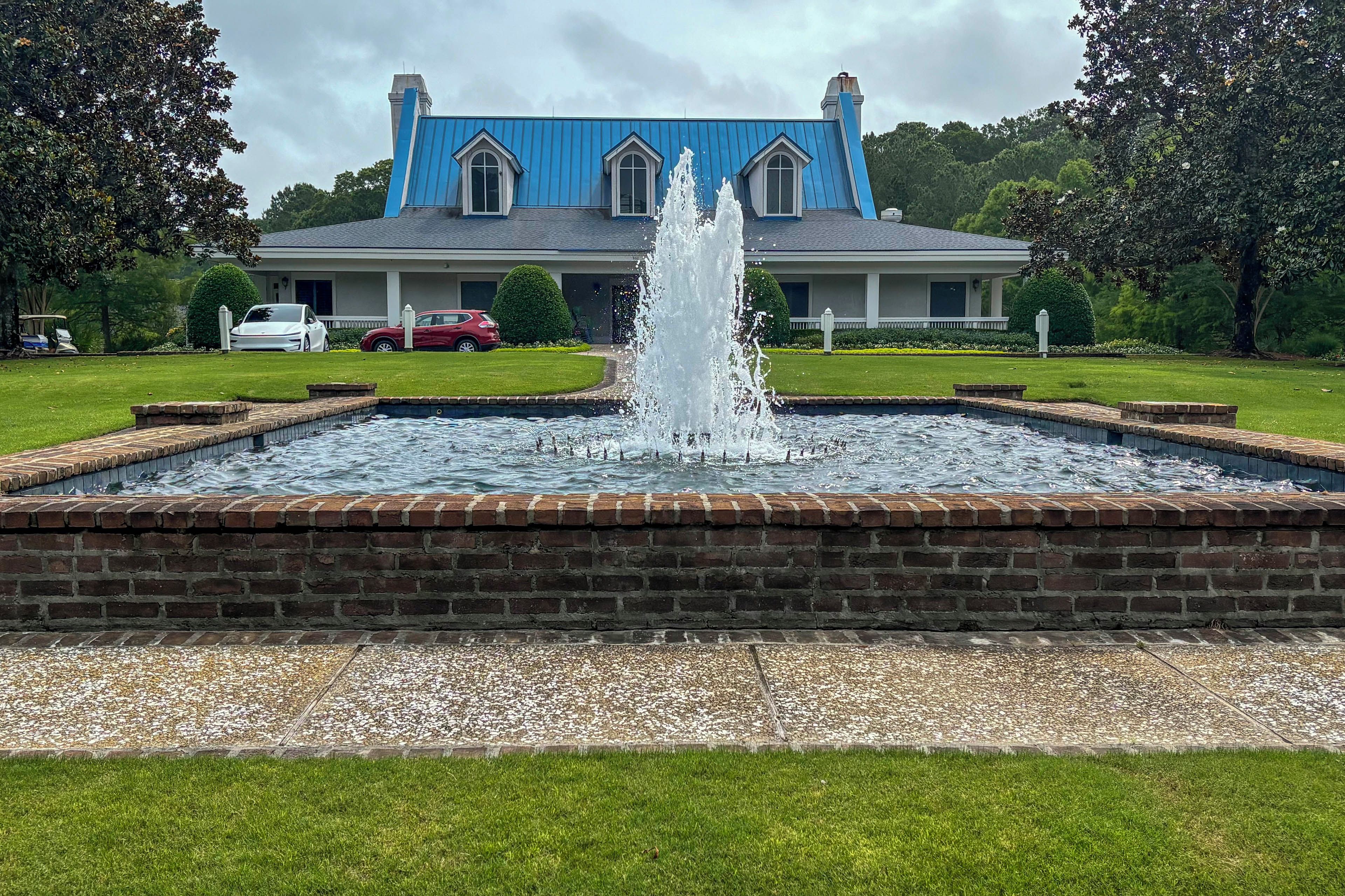 A large blue building with a fountain in front.