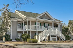 A two-story house with a front porch, a staircase, and a garage. - Pool & Hot Tub Access: True Blue Golf Resort Condo (Pawleys Island)