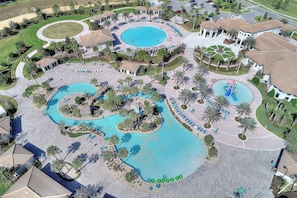 Vista aérea de um resort com várias piscinas, palmeiras e áreas de descanso.