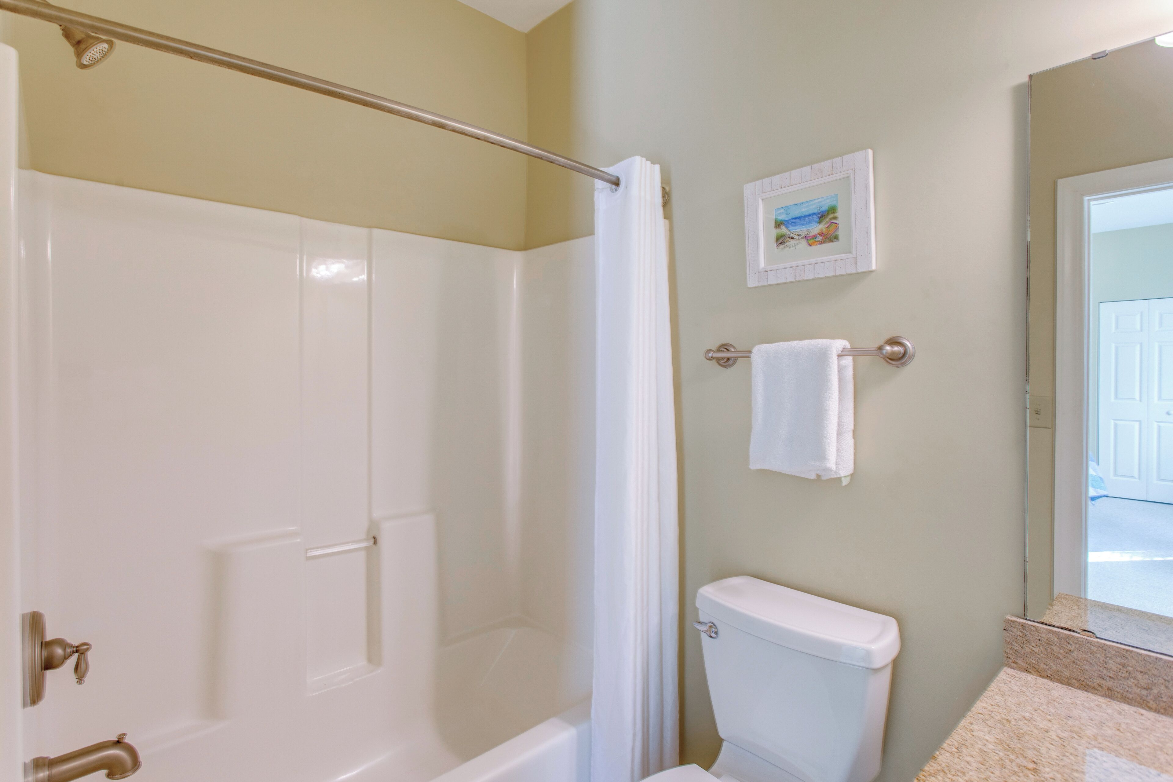 Een badkamer met een bad, toilet en douchegordijn.