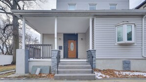 A two-story house with a front porch, a front door, and a small window on the right side. - Explore Nyc, Parks & Beaches! Top-floor Apt (Mount Vernon)